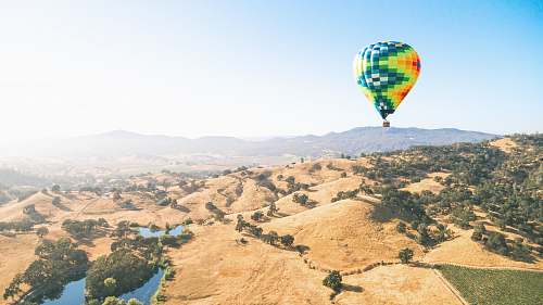 landscape green and orange hot air balloon flying over the mountains balloon